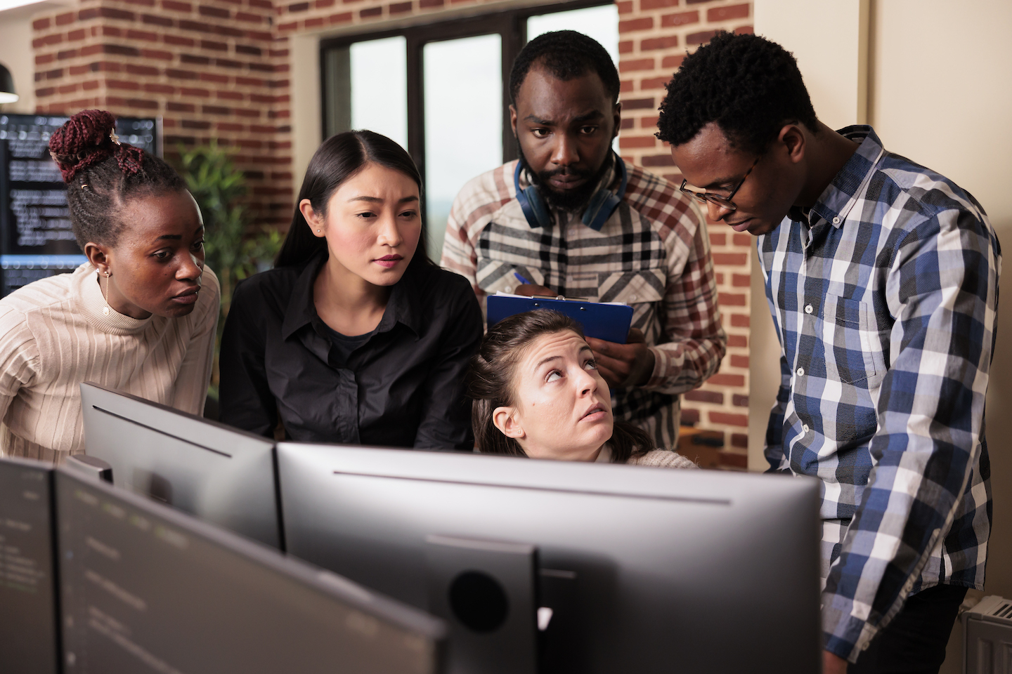 Diverse team of system engineers analyzing html script