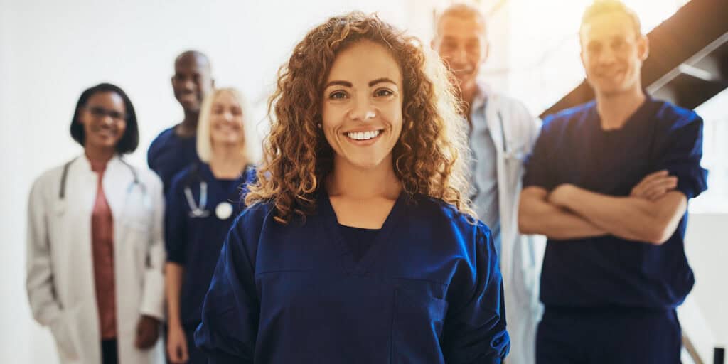 A diverse group of health care workers smiling at the camera.