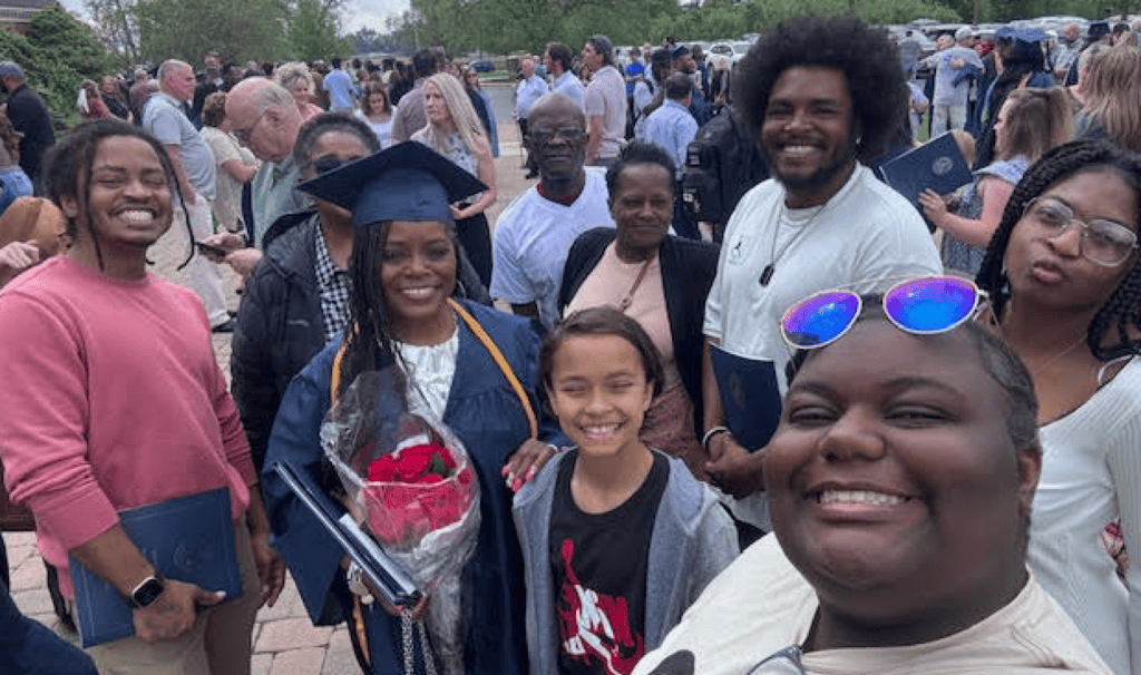 Graduate Michelle smiles with family at MVNU graduation ceremony