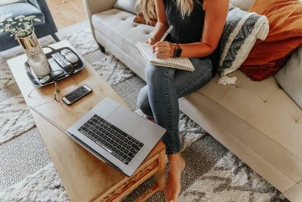 Woman sitting on a couch looking at a laptop